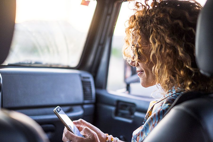 FAQs - Closeup View of Woman Wearing Sunglasses Sitting in the Passenger Seat of a Car and Using a Cellphone